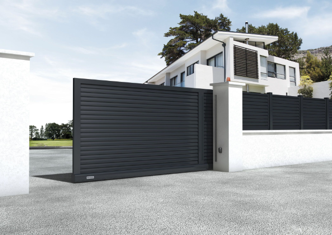 a white house with a black automatic gate